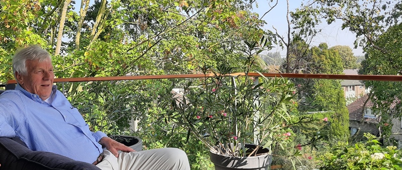 Henk Jan Overbeek op het balkon van zijn appartement in Residentie Molenwijck